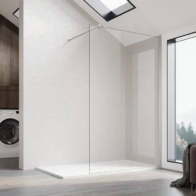 A modern bathroom with a walk-in shower, washing machine, and a large window overlooking a forest.