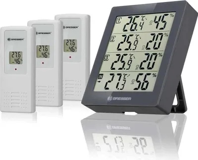 A digital weather station with three remote sensors and a main display unit.