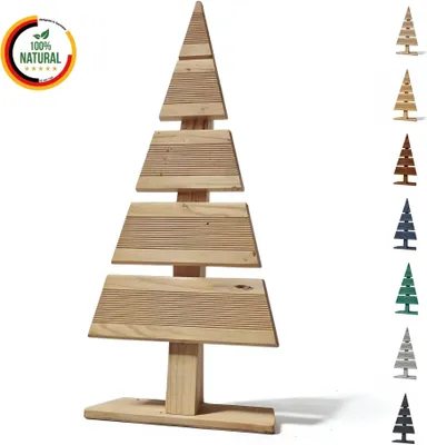 A wooden Christmas tree decoration is displayed against a white background. To the left, there is a circular overlay indicating '100% Natural' with a German flag motif. To the right, there is a vertical strip showcasing the same tree in various colors.