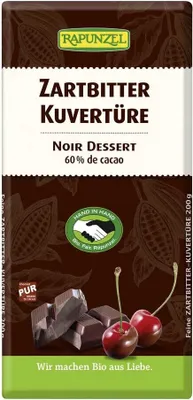 A product shot of a chocolate bar wrapper with some chocolate pieces and cherries.