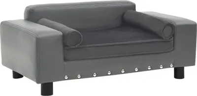 A gray dog sofa with bolster pillows and silver studs along the front base.