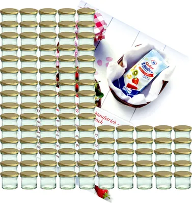 A large collection of small glass jars with gold lids, arranged in rows, with a small packet of 'Gelierzauber' and a strawberry in the foreground.