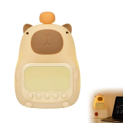 A cute capybara-shaped alarm clock with a night light function is shown against a white background. A smaller inset image shows the alarm clock lit up on a desk next to a laptop.