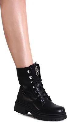 A close-up shot of a woman's lower leg and a black boot.
