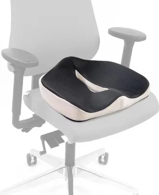 A black and white orthopedic seat cushion is placed on a chair.