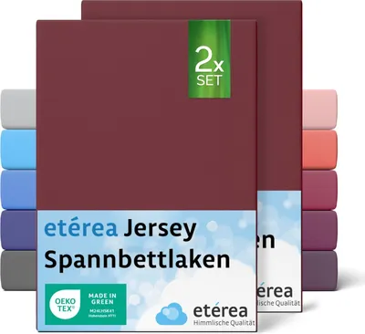 A stack of folded jersey fitted sheets in various colors, with the front sheet prominently displaying branding and product information.