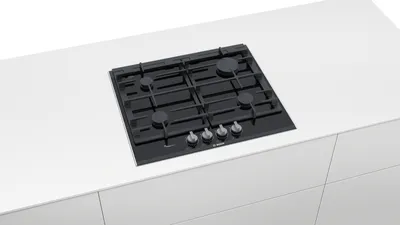 A black gas cooktop is installed on a white countertop.