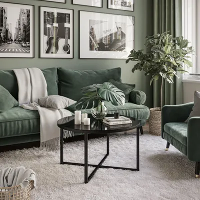 A living room scene with a green sofa, coffee table, and artwork.