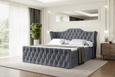 A bedroom scene with a large upholstered bed as the main focus.