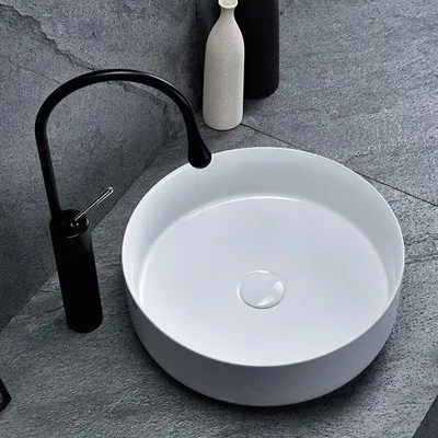 A modern bathroom sink with a black faucet.