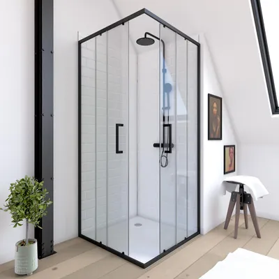 A modern corner shower cabin with a black frame and clear glass doors, set in a bright bathroom with wooden floors and decorative pictures on the wall.