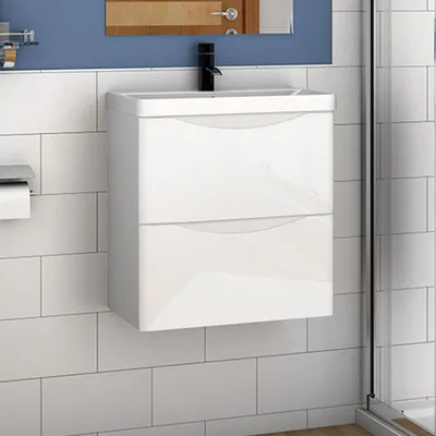 A white bathroom vanity with two drawers is mounted on a tiled wall.