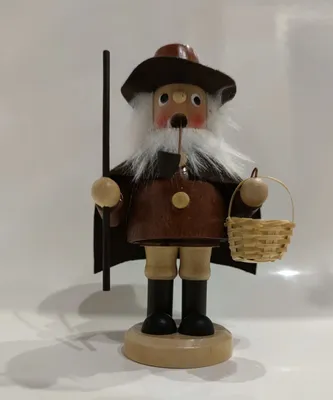 Ein Räuchermännchen Pilzsammler mit weißem Bart braunem Mantel und Hut Er trägt einen Korb mit Pilze