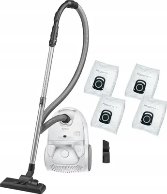 A white vacuum cleaner with its accessories, including four dust bags and a crevice tool, is displayed against a white background.