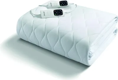 A folded white electric blanket with two controllers on top, displayed on a white background.
