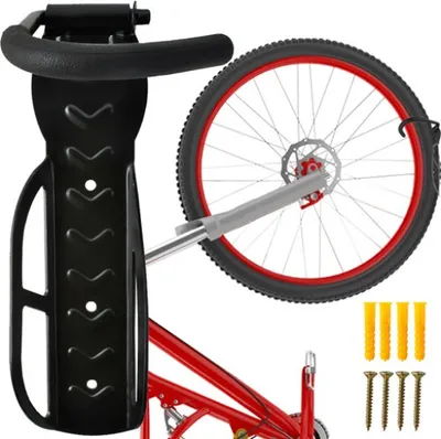 A black bicycle wall mount holding a bicycle wheel and part of the frame. Mounting hardware (screws and wall plugs) are shown to the right.
