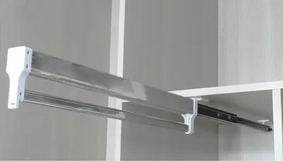 A close-up view of a telescopic clothes rail mounted inside a wardrobe.
