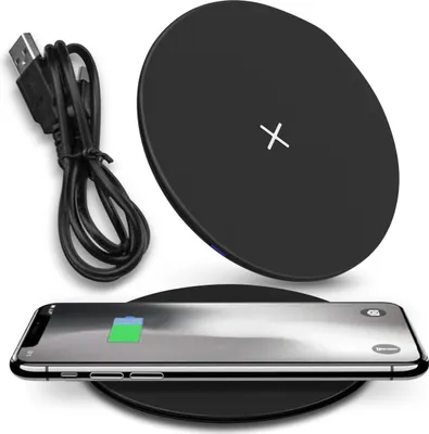 A black wireless charger with a USB cable and a smartphone being charged.