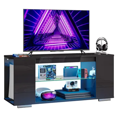A modern black TV stand with a large TV displaying a purple geometric pattern, and various gaming accessories on display.