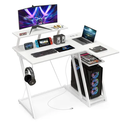 A white gaming desk setup with a computer, monitor, laptop, and accessories.