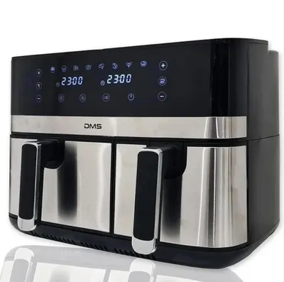 A studio shot of a black and silver dual-chamber air fryer with its digital display illuminated.