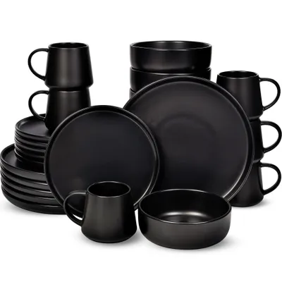 A collection of black ceramic dinnerware, including plates, bowls, and mugs, arranged on a white background.