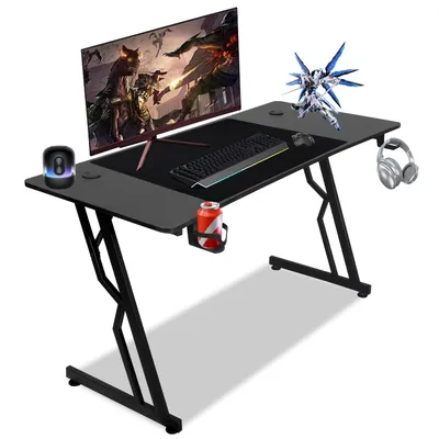 A gaming desk setup with a monitor, keyboard, mouse, headphones, and a drink.
