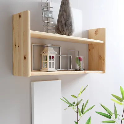A wooden shelf with decorative items on it, including a lantern and a vase.