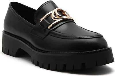 A black loafer with a gold buckle on a white background.