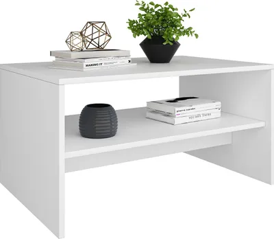 A white coffee table with decorative items and books on it.