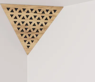 A triangular acoustic panel with a wood finish and a pattern of small black triangles is mounted in a corner where two white walls meet.