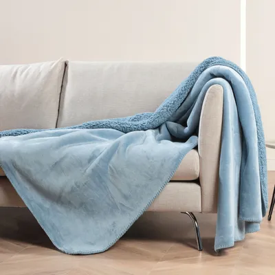 A blue blanket draped over a sofa.