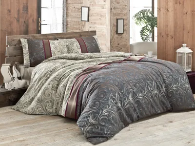 A bed with a duvet and pillows in a bedroom setting.