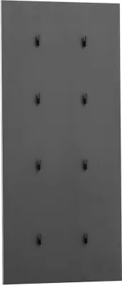 A dark gray wall with several small black hooks arranged in columns.