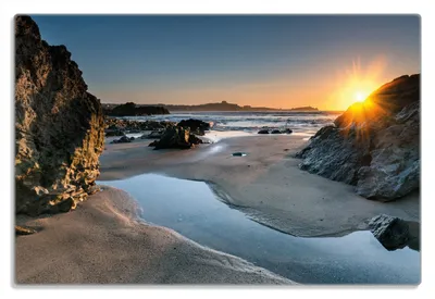 Produktbild von Wallario Frühstücksbrettchen aus Glas 20 x 30 cm mit rutschfesten Füßen, Motiv Sonnenuntergang hinter einem Felsen am Strand