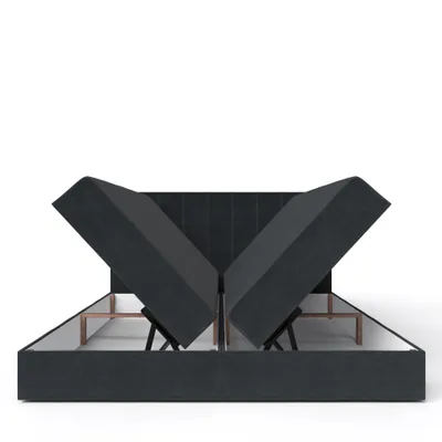 A dark gray upholstered bed frame with the mattress sections lifted to reveal the storage compartments underneath.