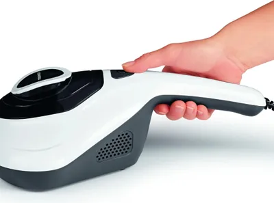A hand is holding a white and gray handheld vacuum cleaner against a white background.