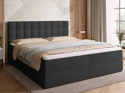 A bed with a headboard and mattress in a bedroom setting.