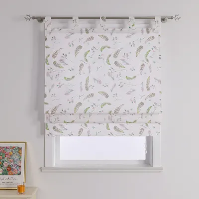 A Roman blind with a feather and floral pattern hangs in front of a window.