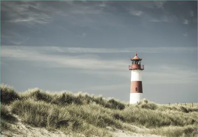 Produktbild von Wallario Fototapete Vliestapete, seidenmatte Oberfläche, einfache Verarbeitung, Größe 200 x 140 cm, Motiv Leuchtturm auf der Düne am Strand