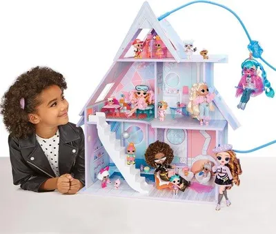 A young girl looks at a dollhouse with dolls.