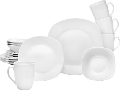 A collection of white porcelain dinnerware, including plates, bowls, and mugs, arranged on a white background.