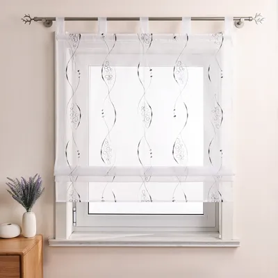 A transparent white curtain with a gray embroidered pattern hangs in front of a window.