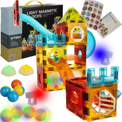 A set of light-up magnetic building blocks arranged in a castle-like structure with balls rolling down a slide.