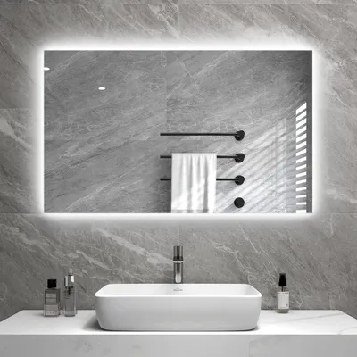A modern bathroom with a large, illuminated mirror above a white sink.