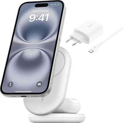 A white wireless charger with a silver iPhone attached, along with a white power adapter and USB-C cable.