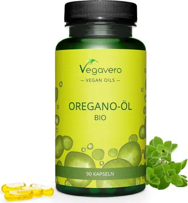 A bottle of Vegavero Oregano-Öl supplements with loose capsules and a sprig of oregano in the foreground.