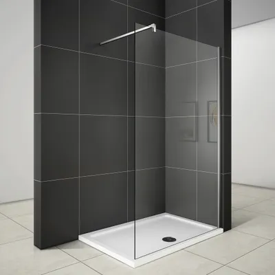 A modern walk-in shower enclosure with a glass panel and a white shower tray, set against dark tiled walls.
