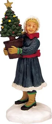 A figurine of a young girl holding a potted Christmas tree.