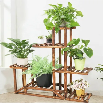 A wooden plant stand with multiple tiers, displaying various potted plants indoors.